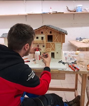 A man is building a nativity scene