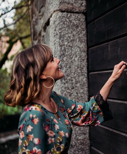 A woman opens an old door